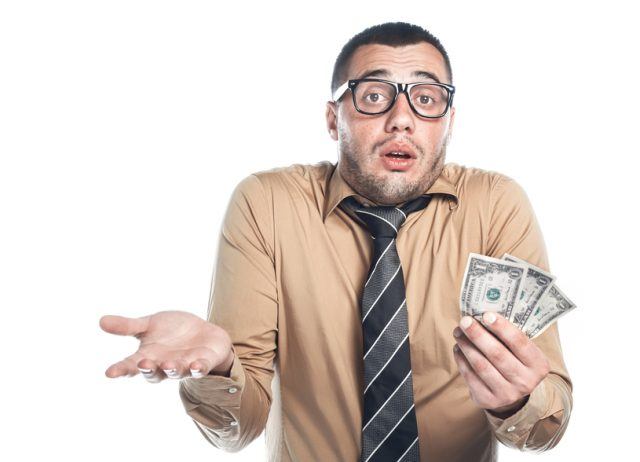 Man looking confused about price of reproductive healthcare while holding dollar notes