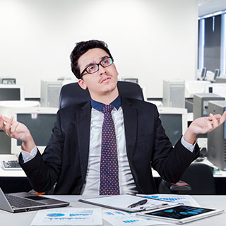 Man working in office shrugs