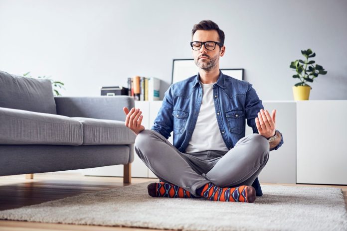Positive man meditating at home